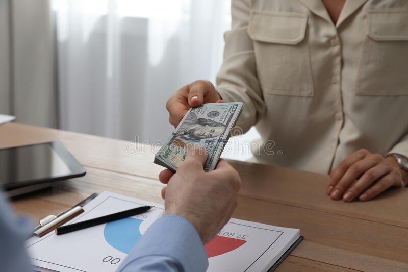 cashier-giving-money-to-businessman-desk-bank-cashier-giving-money-to-businessman-desk-bank-closeup-222978268-1