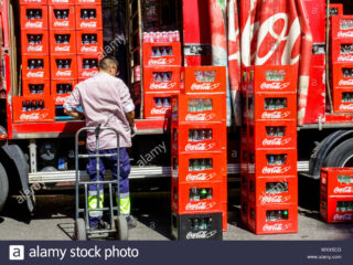 hombre-entrega-botellas-en-cajas-de-coca-cola-camion-coca-cola-camion-de-entrega-espana-wxx5cg