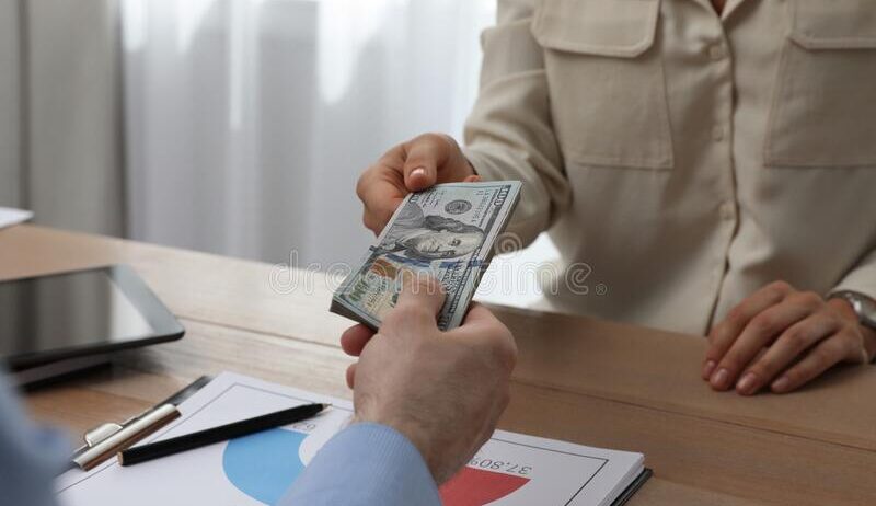 cashier-giving-money-to-businessman-desk-bank-cashier-giving-money-to-businessman-desk-bank-closeup-222978268-1